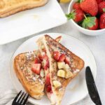 Strawberry banana french toast and a bowl of fresh strawberries.