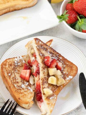 Strawberry banana french toast and a bowl of fresh strawberries.