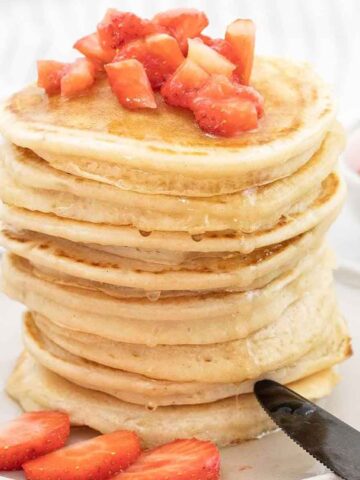 Almond milk pancakes topped with fresh strawberries and drizzled with honey.