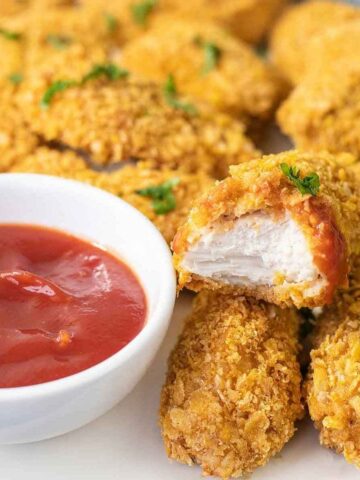 baked cornflake chicken nuggets and a bowl of ketchup.
