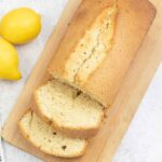 madeira loaf cake on a serving board along with fresh lemons.