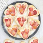 puff pastry strawberry tarts filled with cream cheese and topped with fresh strawberries.