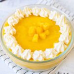 Mango Mousse topped with whipped cream and mango chunks.
