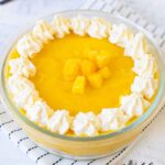 Mango Mousse topped with whipped cream and mango chunks.