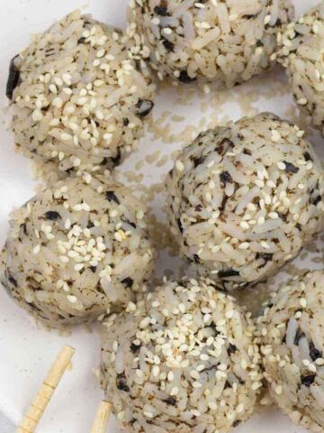 seaweed rice balls and chopsticks on a serving plate.