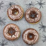 spider web donuts and some spider toys are around them.