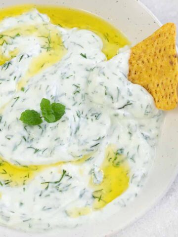 Haydari (Turkish yogurt sauce) topped with olive oil and fresh mint leaves.
