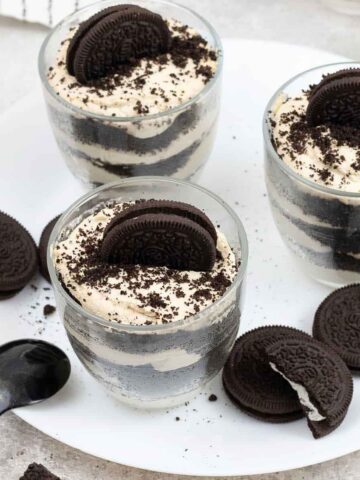 Oreo Tiramisu in glasses and some Oreo cookies are around.