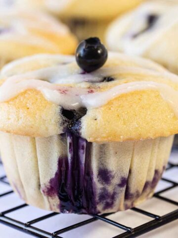 Moist Lemon Blueberry Muffins topped with lemon glaze.